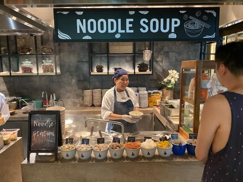 Noodle soup vendor serving a customer