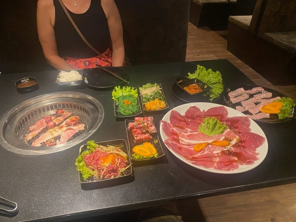 Korean BBQ spread — raw meats and tabletop grill, Thailand