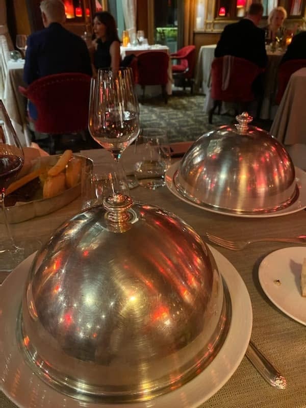 Upscale restaurant table set with silver cloche domes — Venice