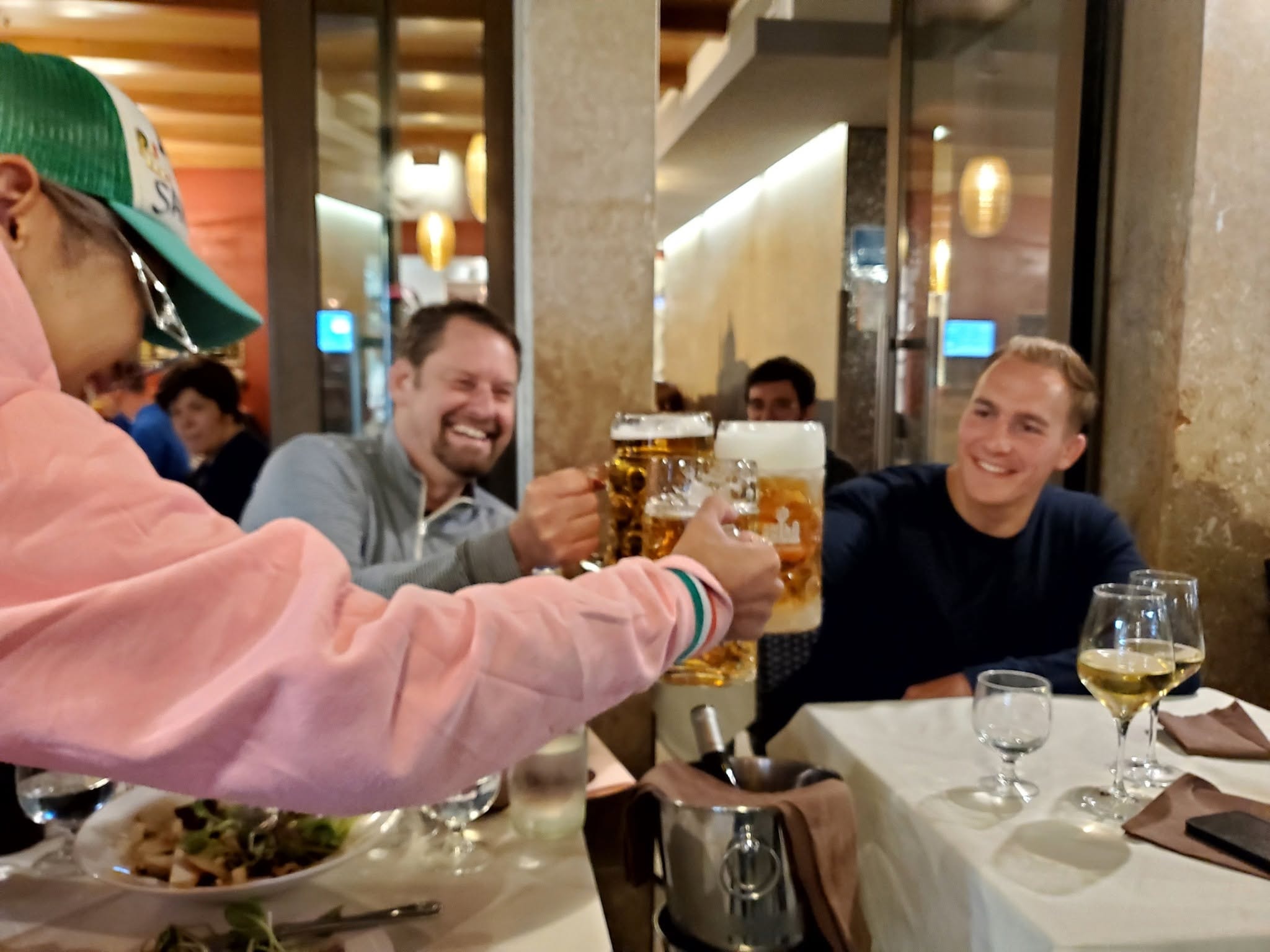 Friends toasting beers at dinner — Venice