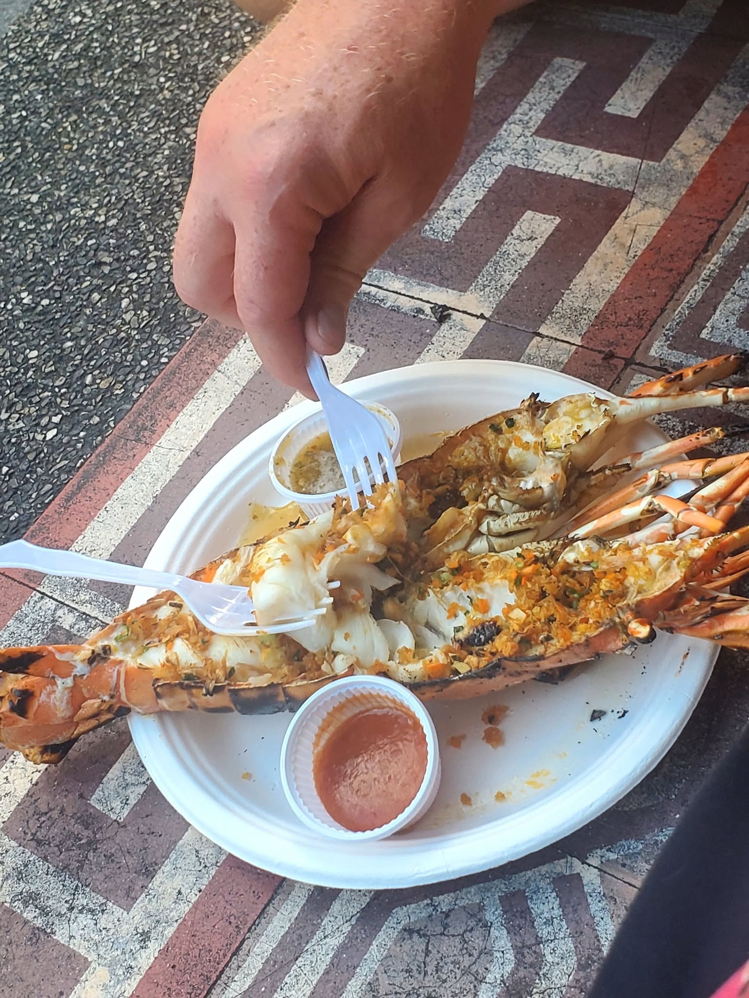 Digging into grilled lobster — Thailand