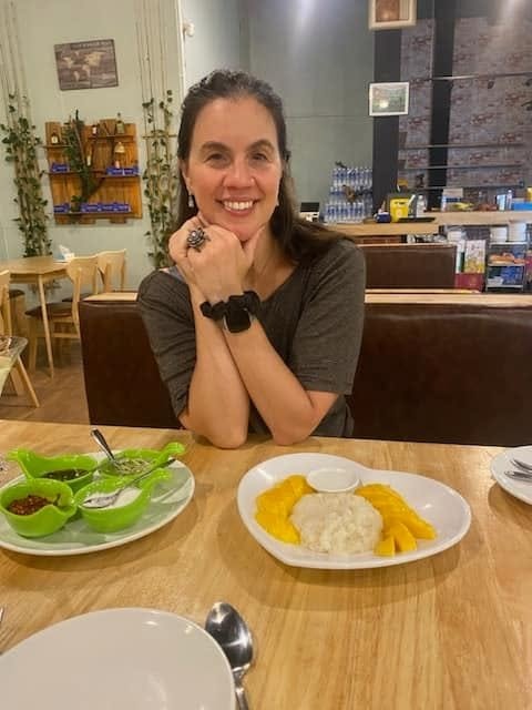 Sherry smiling over mango sticky rice — a Thailand must